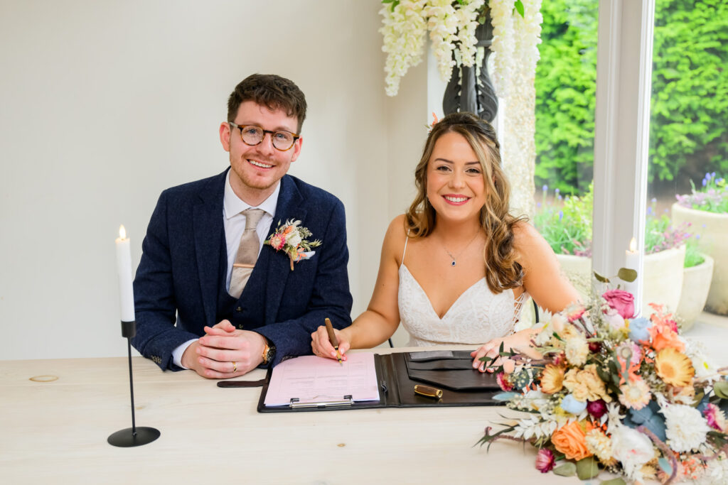 couple signing marriage register at woodborough hall wedding