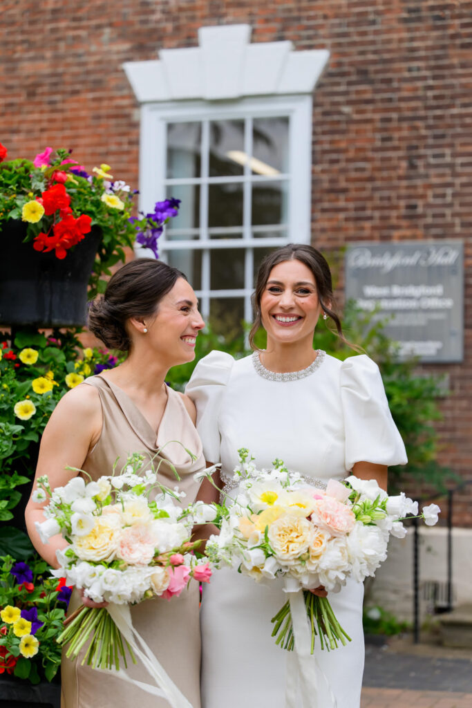 Bride and bridesmaid with bouquets outside West Bridgford Registry Office
