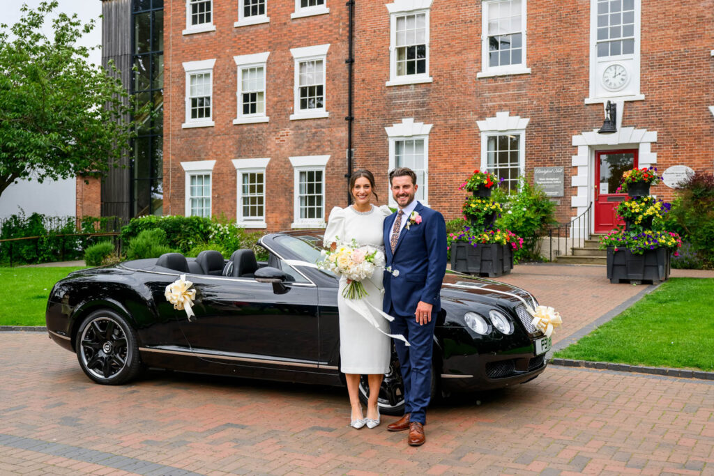 Bride and groom in front of Bentley wedding car outside West Bridgford Registry Office