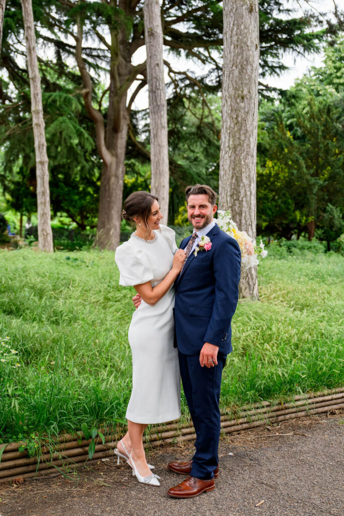 Bride and groom smiling standing among trees in West Bridgford Park