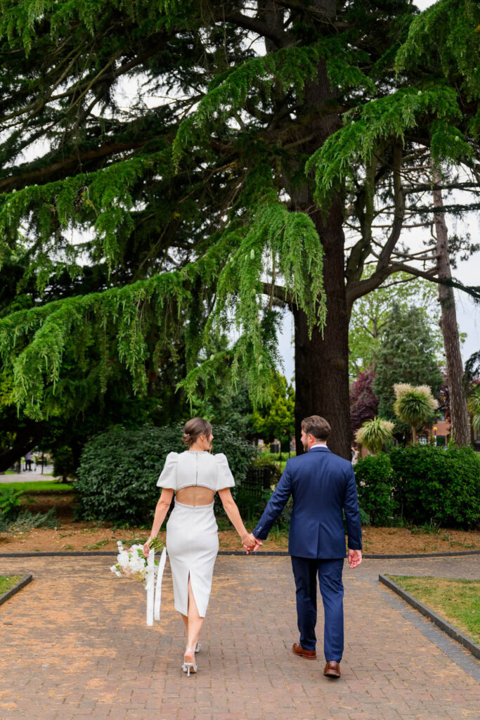 Bride and groom walking through West Bridgford Park after their wedding