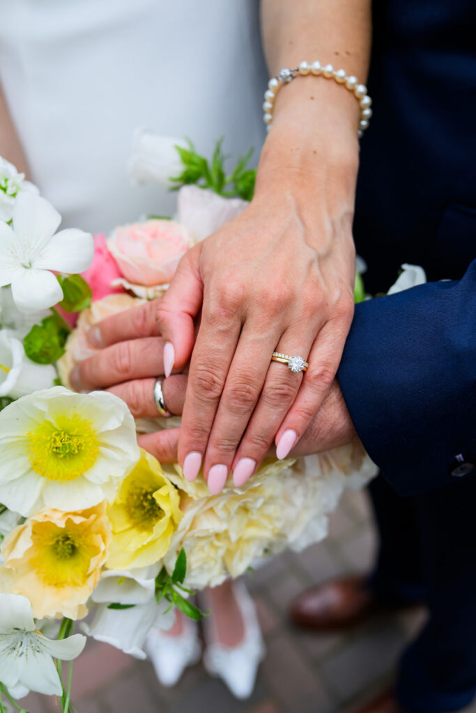 Bride and groom’s wedding rings resting on a bouquet during West Bridgford photography session