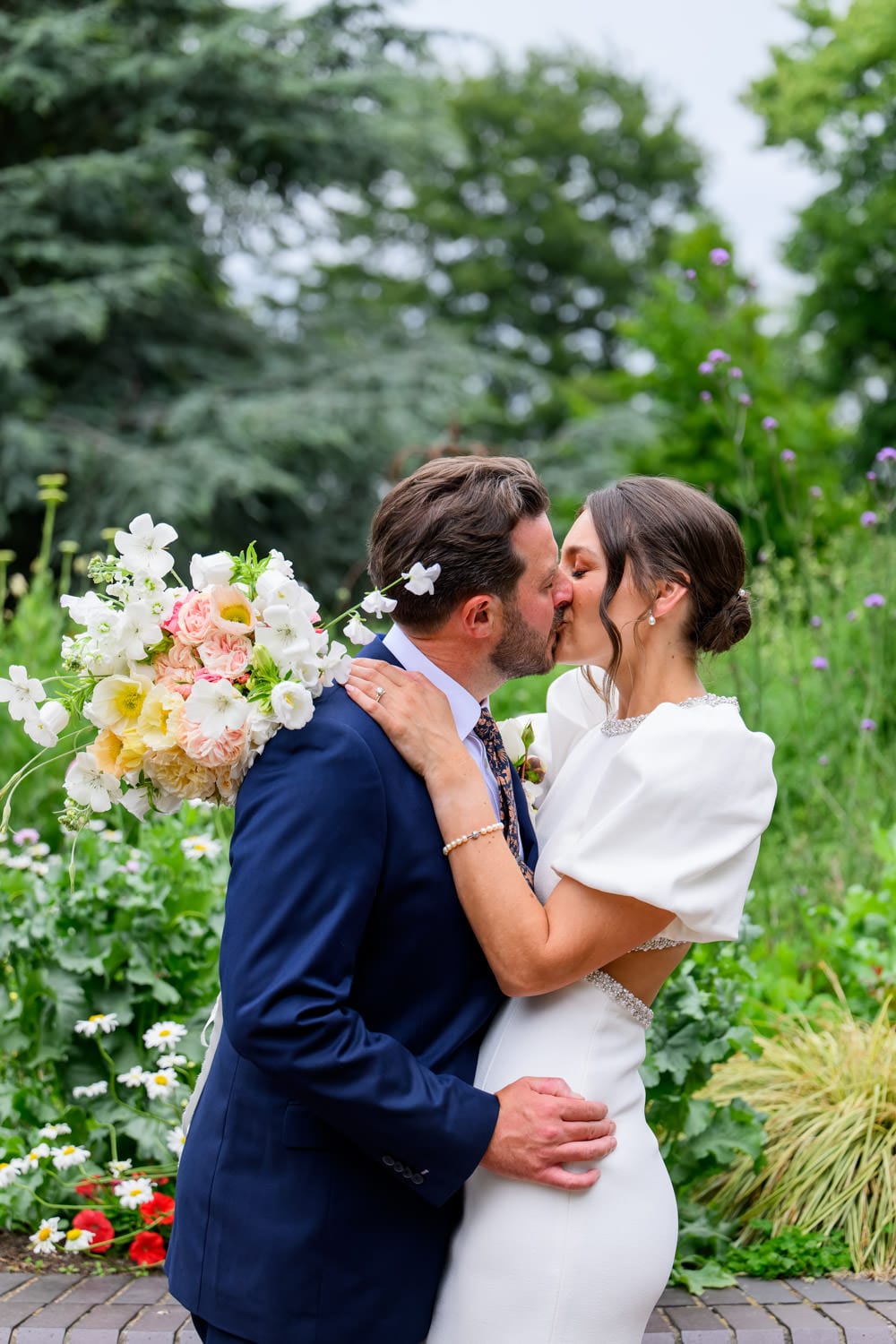 Bride and groom kissing during wedding photos in West Bridgford Park