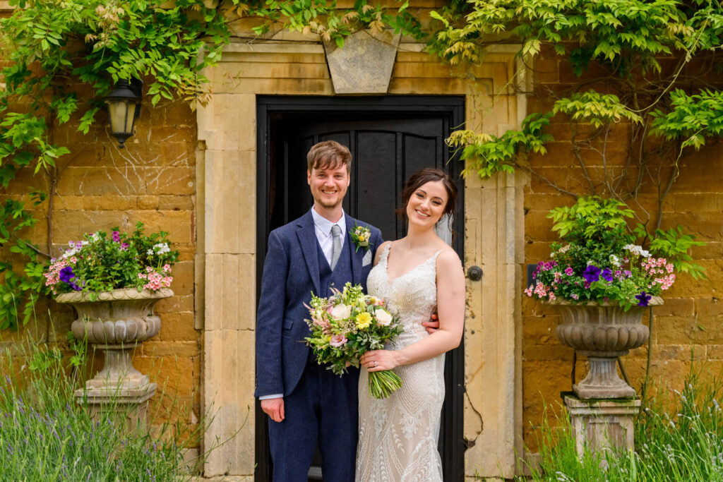 Bride and groom portrait outside the historic stone manor house in Lincolnshire
