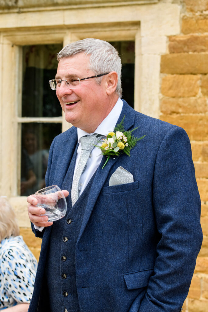 Wedding guest enjoying drinks reception outside Allington Manor in Lincolnshire