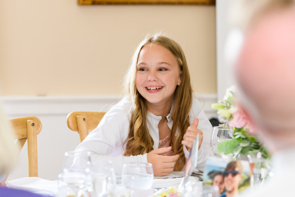 Young guest smiling during speeches at the reception