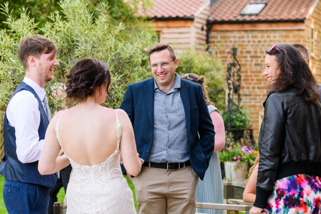Bride chatting with guests during outdoor drinks reception