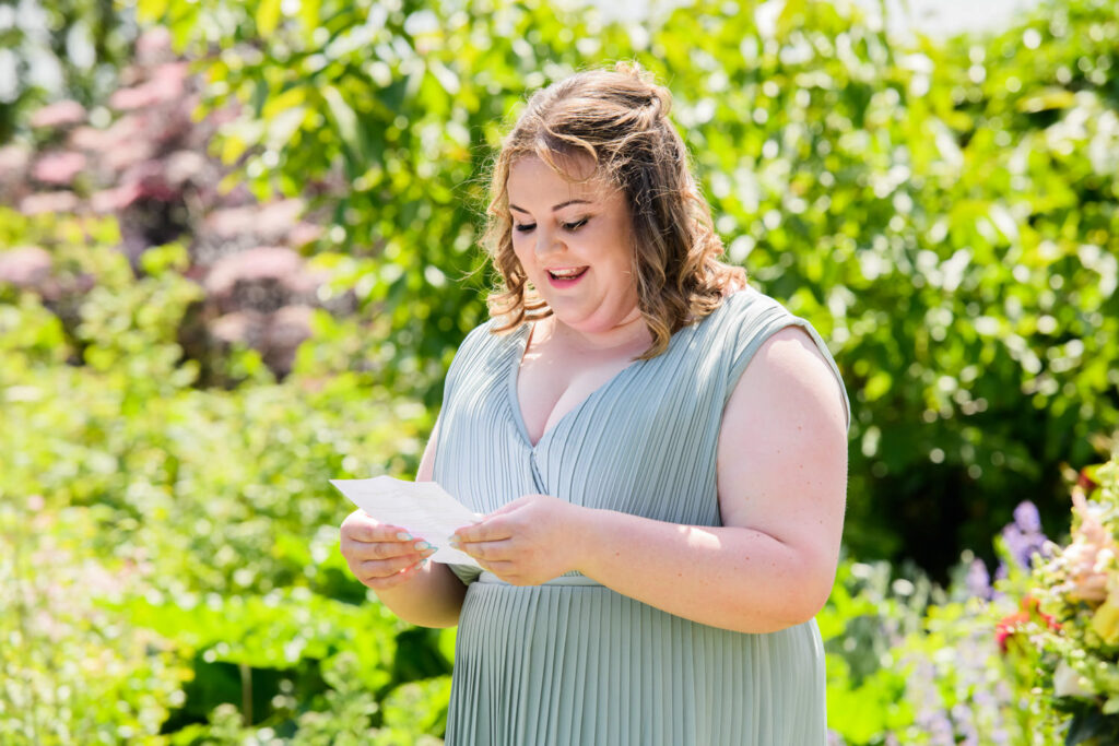Bridesmaid reading during outdoor wedding ceremony at Allington Manor