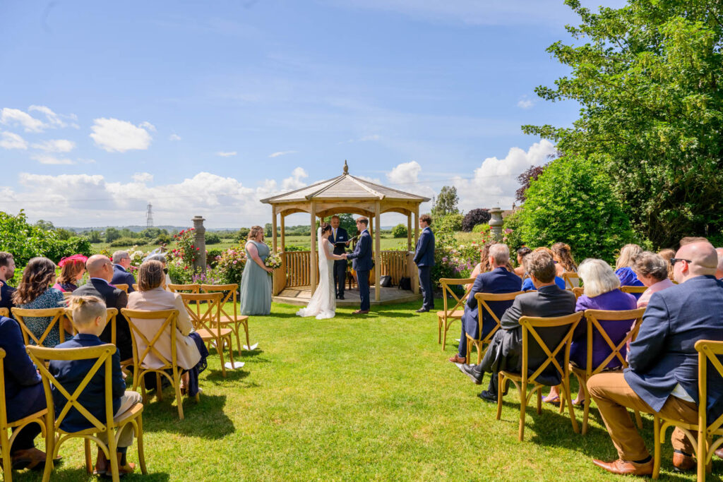 Outdoor wedding ceremony at Allington Manor in Lincolnshire with guests seated around the garden gazebo