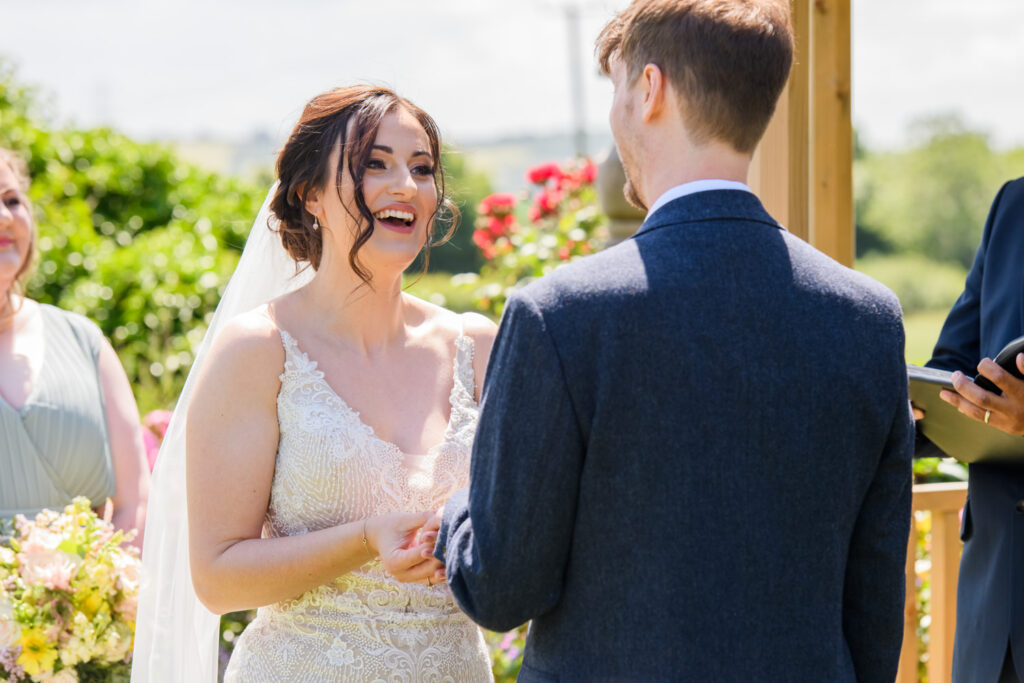 Bride smiling during outdoor wedding ceremony at Allington Manor wedding venue