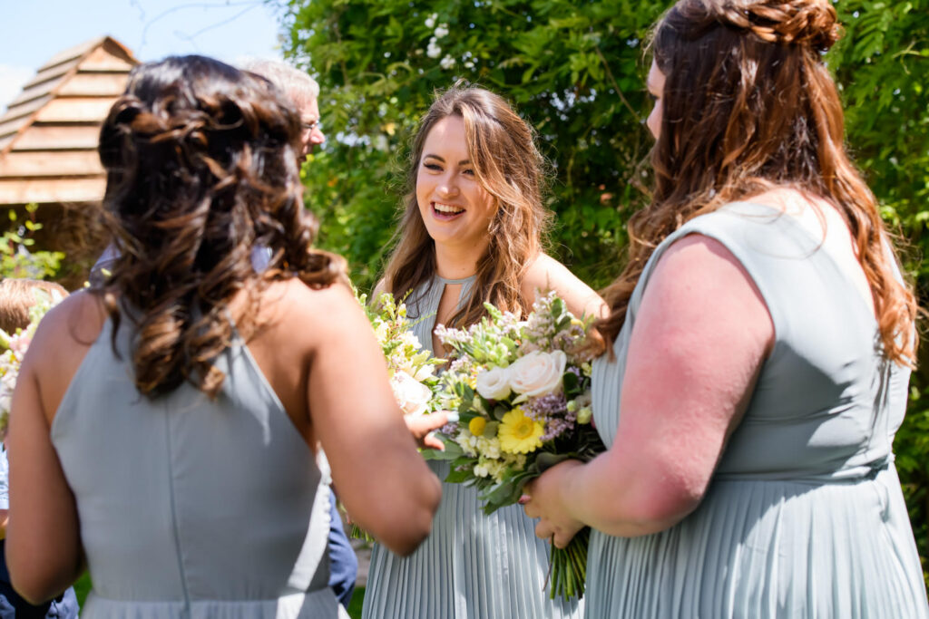 Bridesmaids chatting together during garden drinks reception at Allington Manor