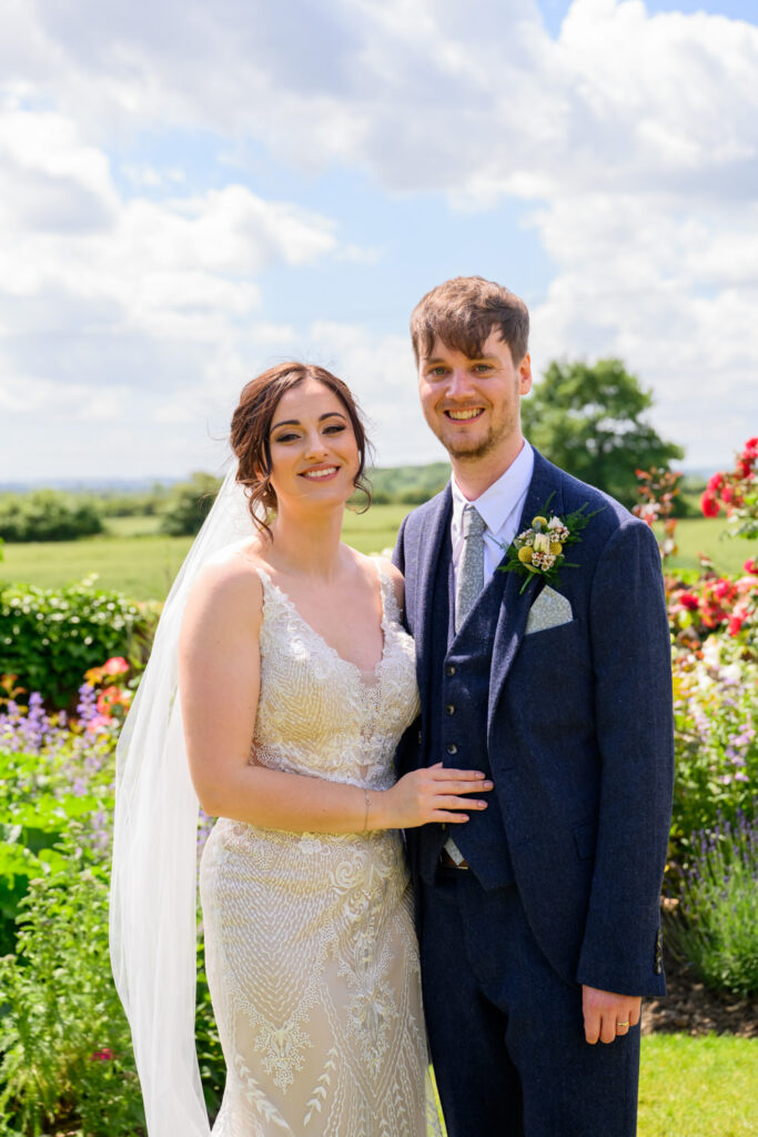 Bride and groom smiling together in the garden after their ceremony