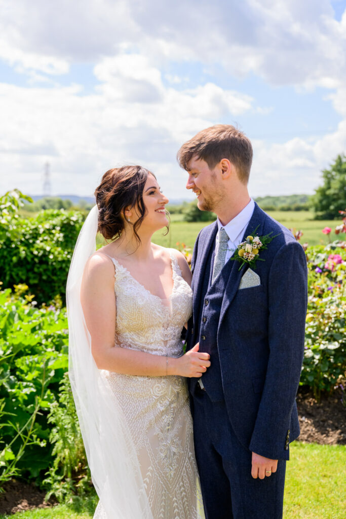 Bride and groom looking at each other in the summer garden