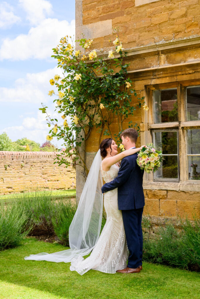 Bride and groom embracing outside Allington Manor in Lincolnshire