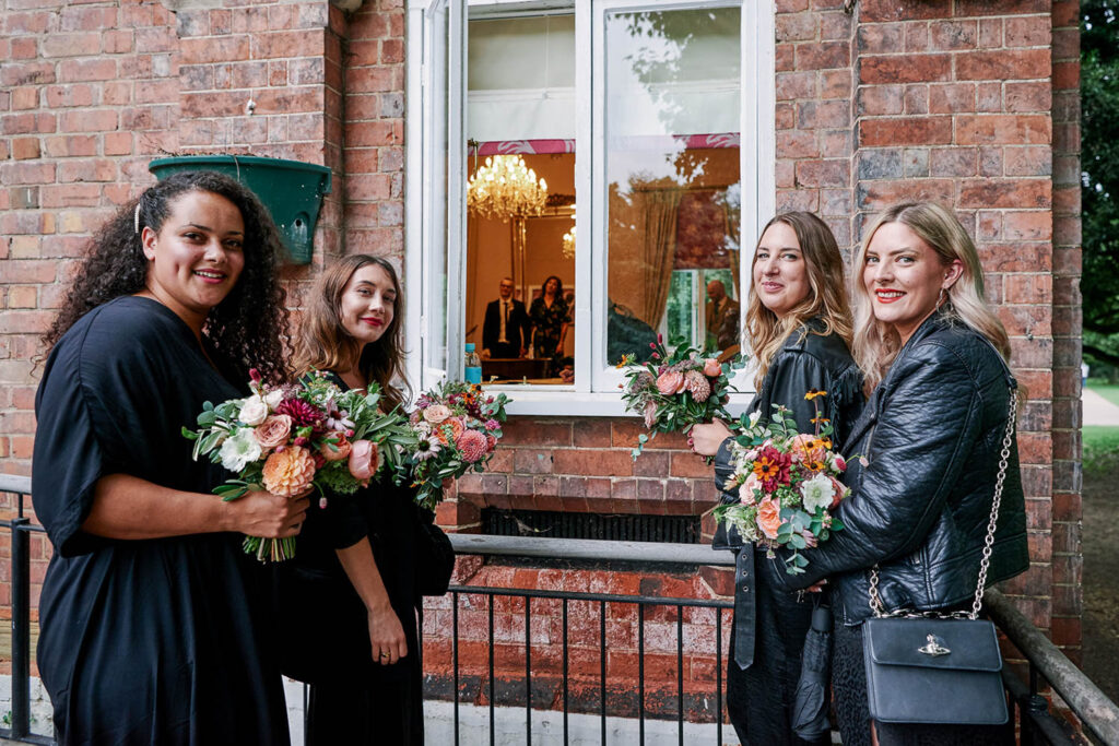 Wedding party holding colourful bouquets outside a Nottingham registry office