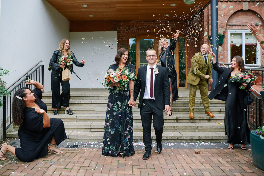 Couple walking through confetti outside West Bridgford Registry Office in Nottingham