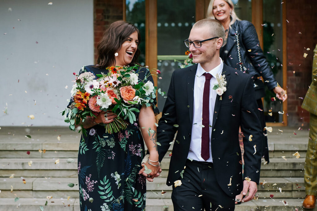 Couple walking through confetti outside a Nottingham registry office wedding