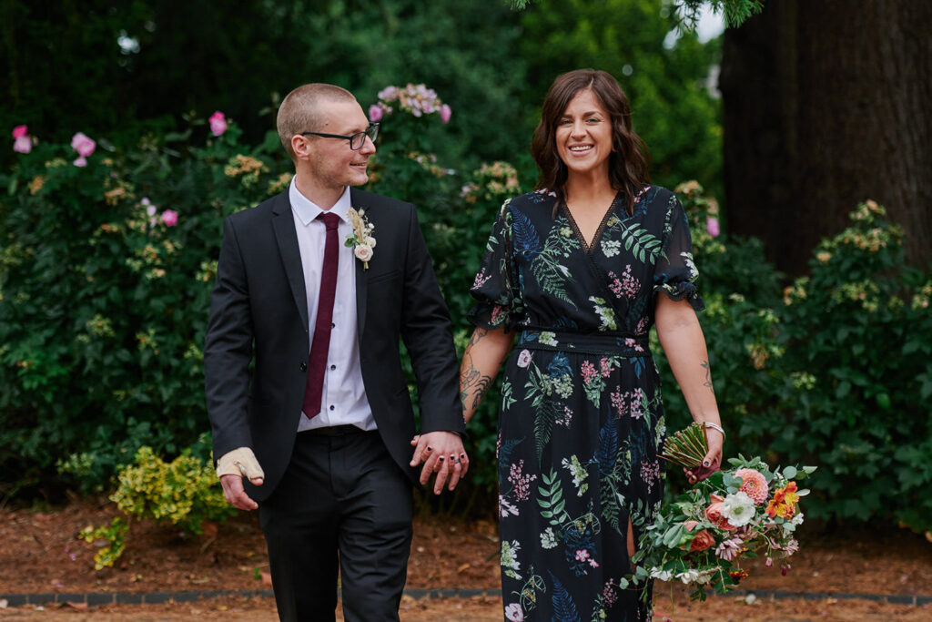 Bride and groom walking through West Bridgford Park after their wedding ceremony