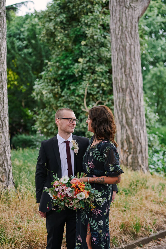 Bride and groom smiling during relaxed wedding portraits in West Bridgford Park