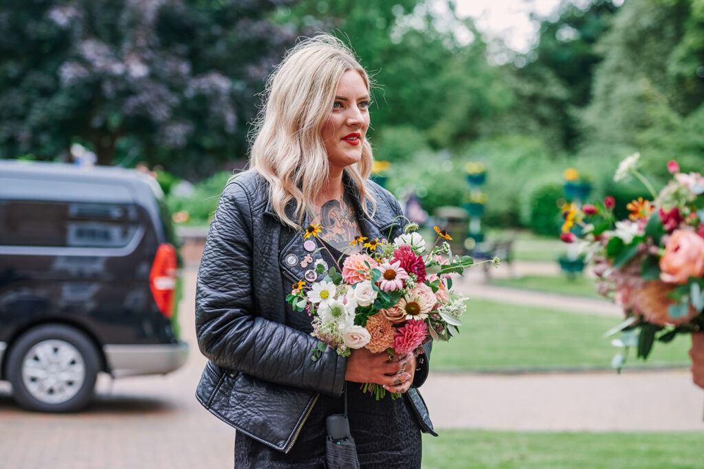 Wedding guest holding a colourful bouquet at an alternative Nottingham wedding