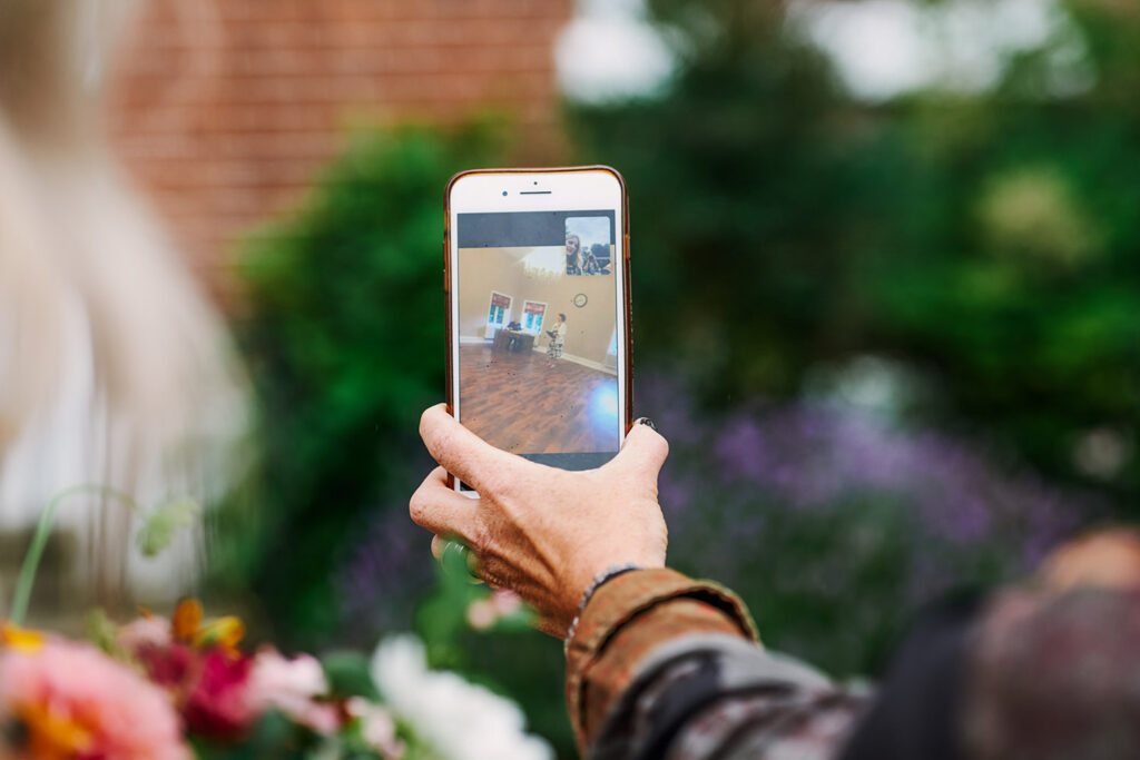 Guests using facetime to watch wedding ceremony on a phone