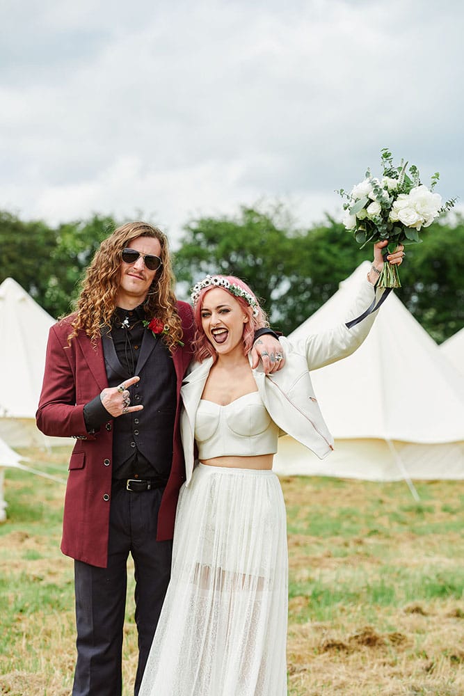 Pheasantry Brewery Nottingham Wedding Photography Rock ’n’ roll bride and groom celebrating in front of festival tipis at The Peasantry Brewery, Nottingham