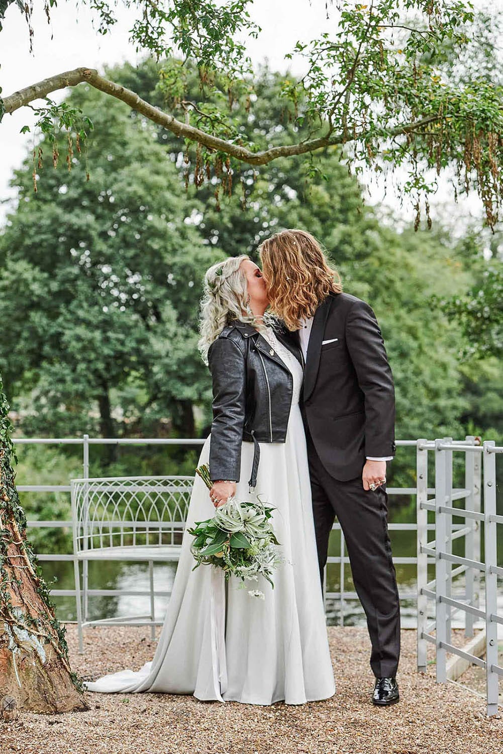 The West Mill Wedding Photography Bride and groom kissing in front of trees at The West Mill in Derby