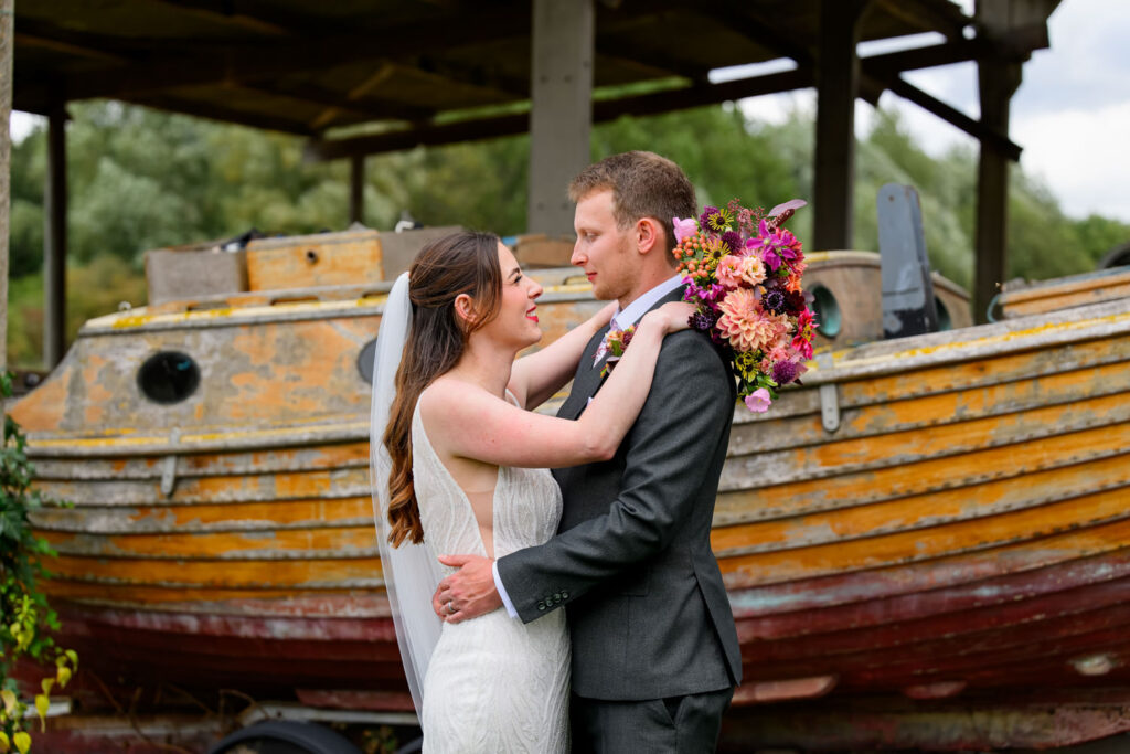 Bride and groom portrait at Willow Marsh Farm wedding venue in Leicestershire with rustic boat backdrop