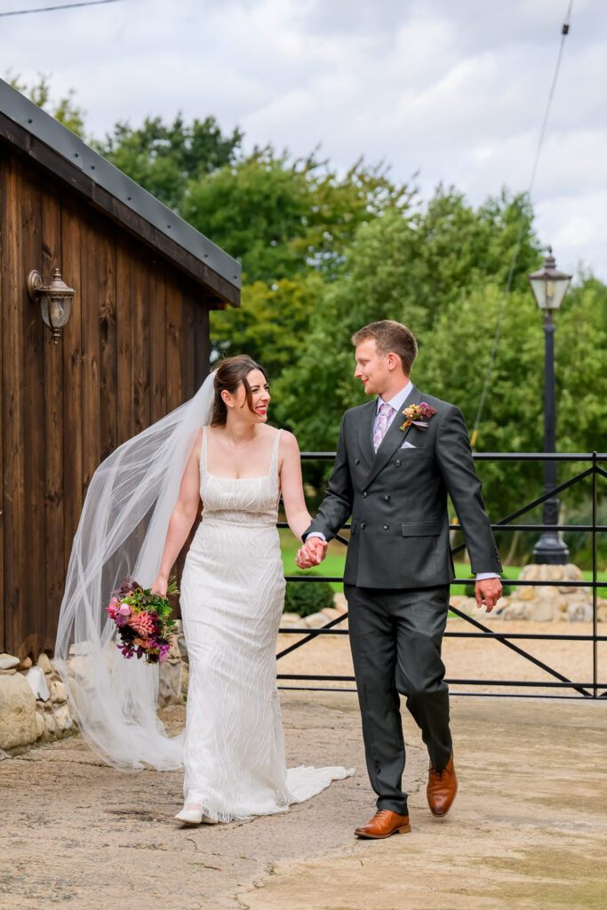 Bride and groom walking hand in hand during relaxed wedding portraits