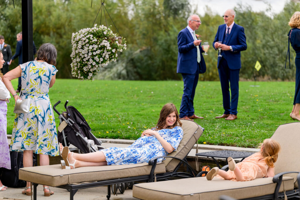 Children relaxing on sun loungers during outdoor wedding drinks reception