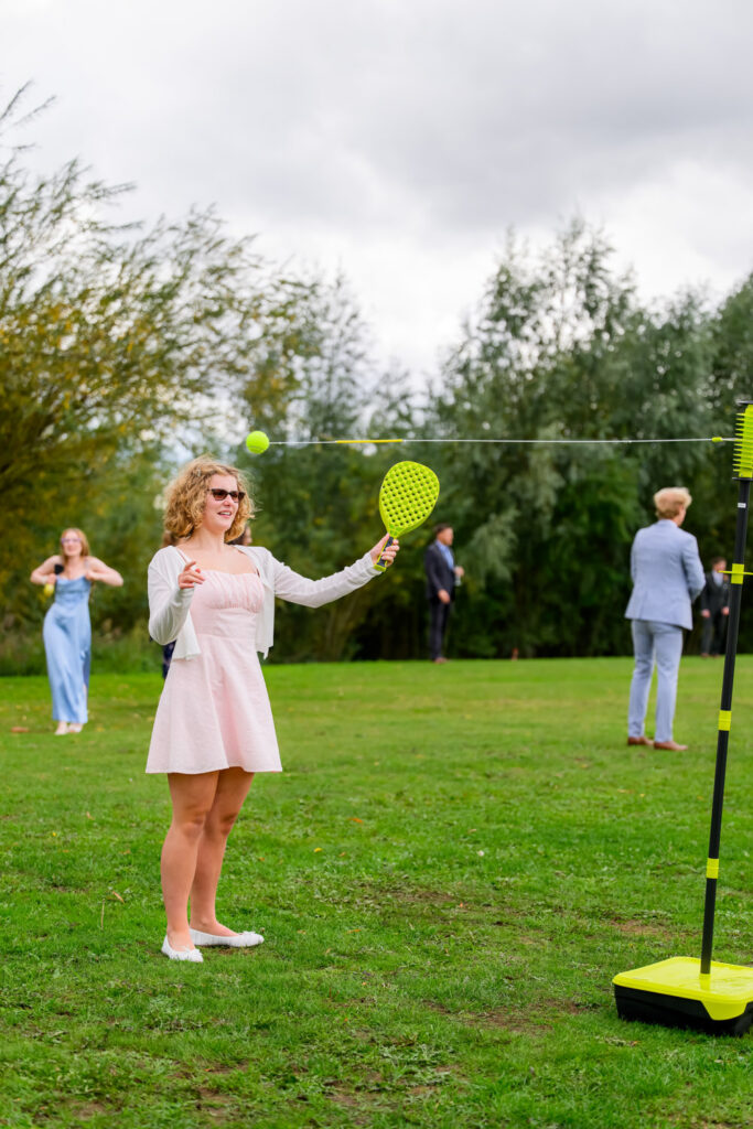 Wedding guest playing outdoor garden game during countryside wedding reception