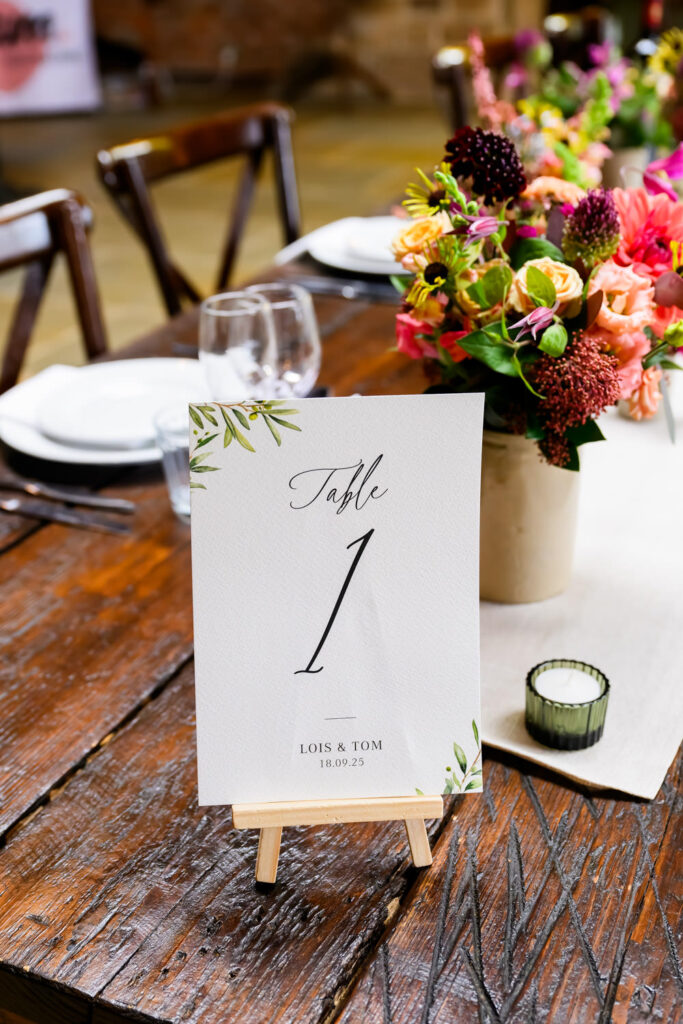 Rustic wedding table styling with colourful flowers and table number