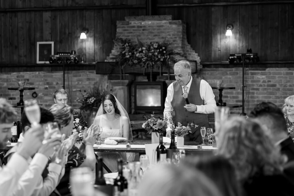 Guests raising glasses for toast during wedding speeches
