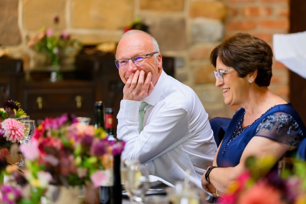 Wedding guests laughing during heartfelt wedding speech