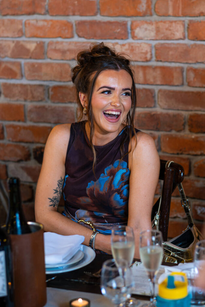 Wedding guest laughing during speeches at reception