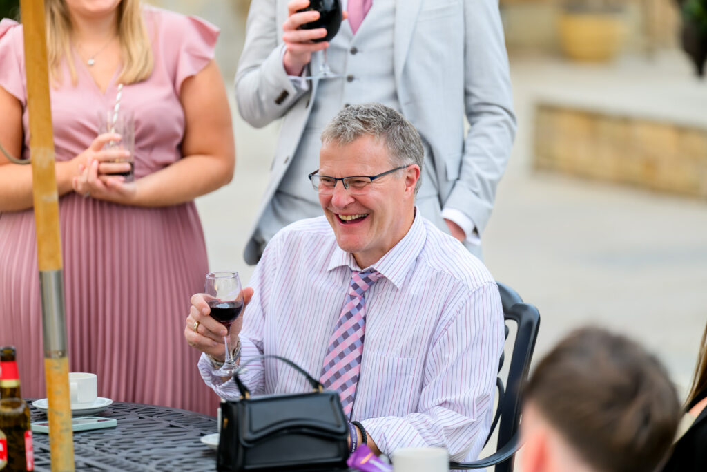 Guests chatting and enjoying drinks during outdoor wedding reception
