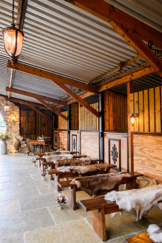Barn wedding ceremony aisle with wooden benches and rustic interiors