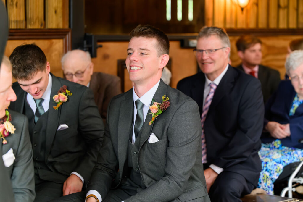 Wedding guest smiling during barn ceremony