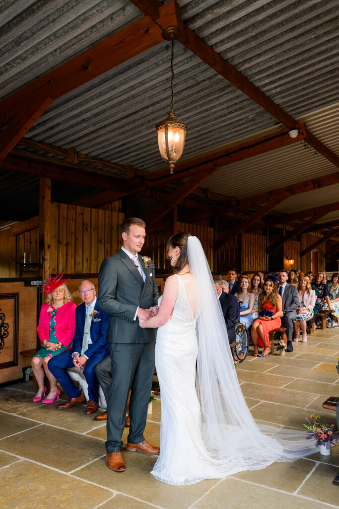 Bride and groom standing together during barn wedding ceremony