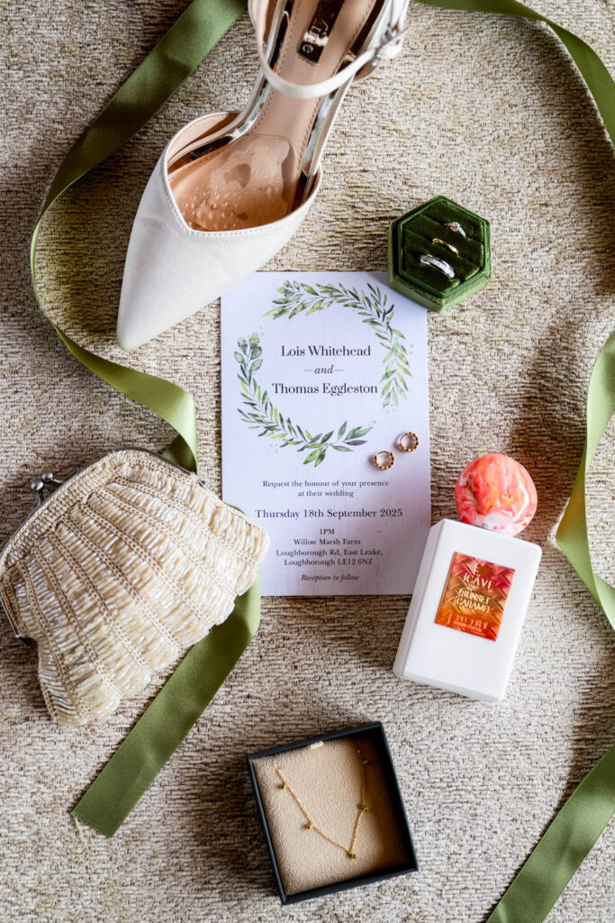 Willow Marsh Farm wedding details including invitation, shoes, perfume and olive green ribbon styling