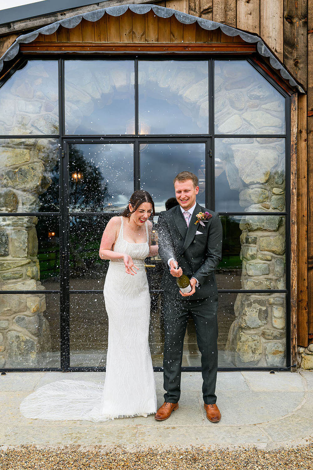 Wedding couple spraying champagne at Willow Marsh Farm in Nottingham