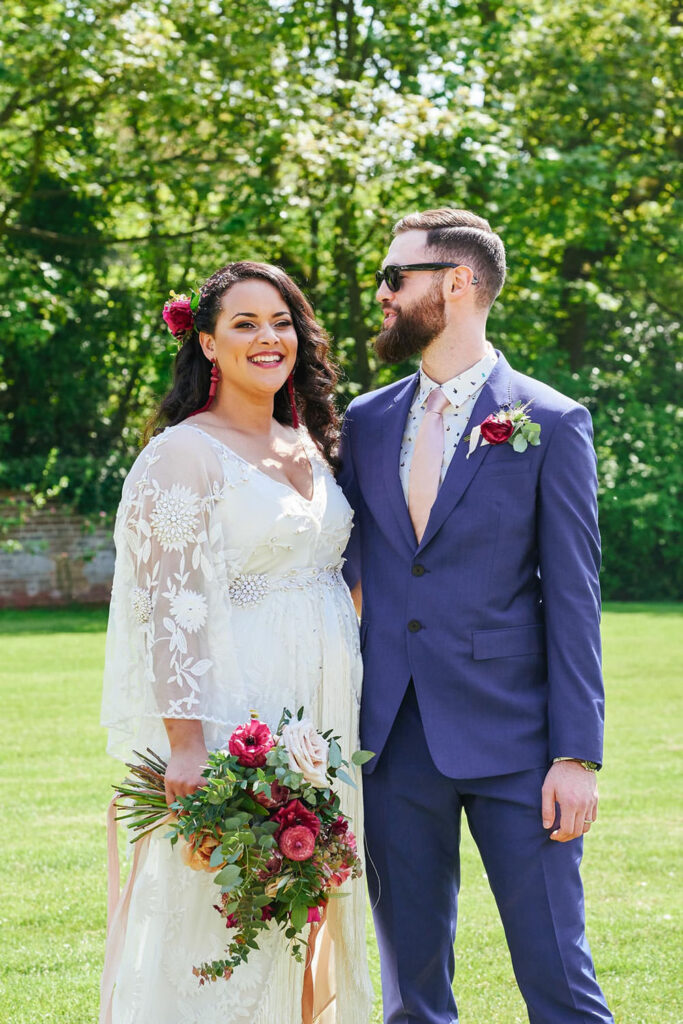 Wedding couple laughing together outside, surrounded by greenery at Pippley Walled Garden