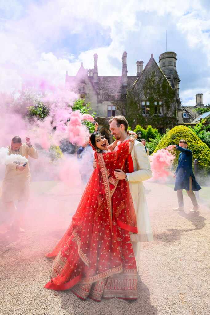 Bride and groom celebrating with smoke bombs during fun wedding portraits at Manor by the Lake.