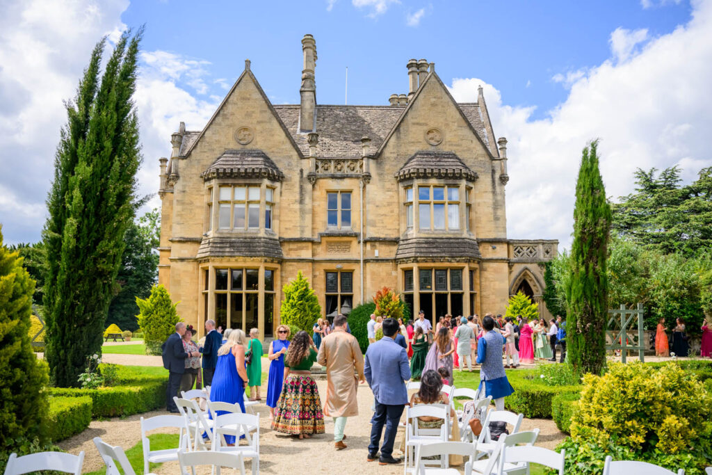 Guests gathering in the gardens outside Manor by the Lake before an outdoor wedding ceremony.