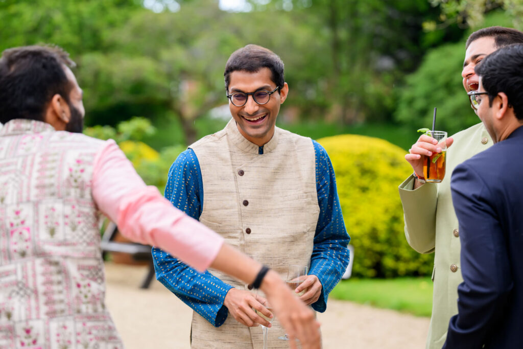 Wedding guests chatting in the grounds of Manor by the Lake before the ceremony.