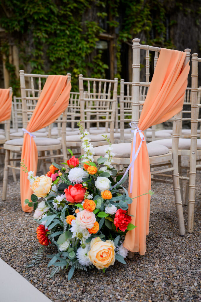 Floral aisle decoration and chairs prepared for a Manor by the Lake wedding ceremony.