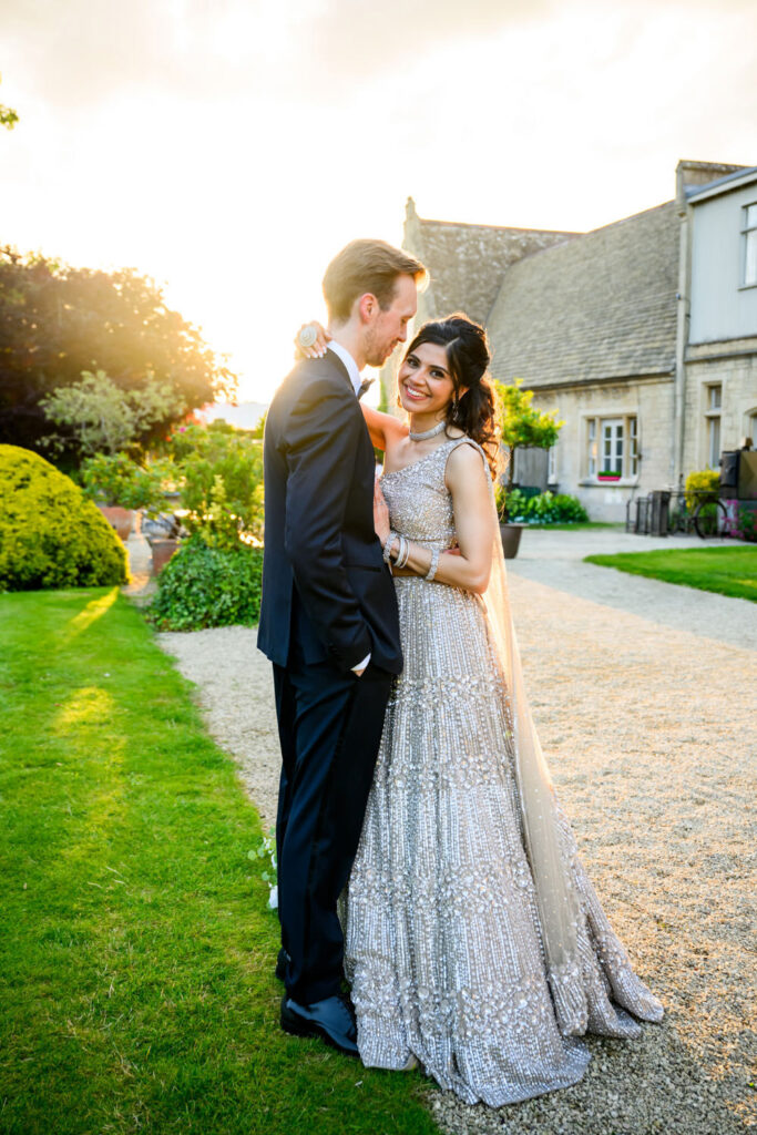 Bride and groom embracing at sunset during wedding photography portraits.