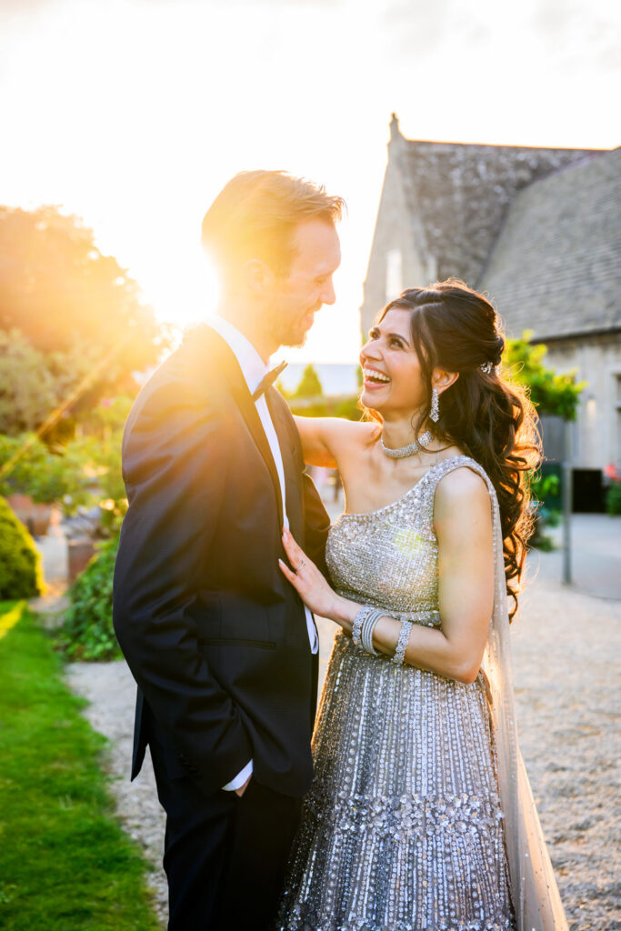 Candid wedding portrait of the couple laughing together at Manor by the Lake during golden hour.