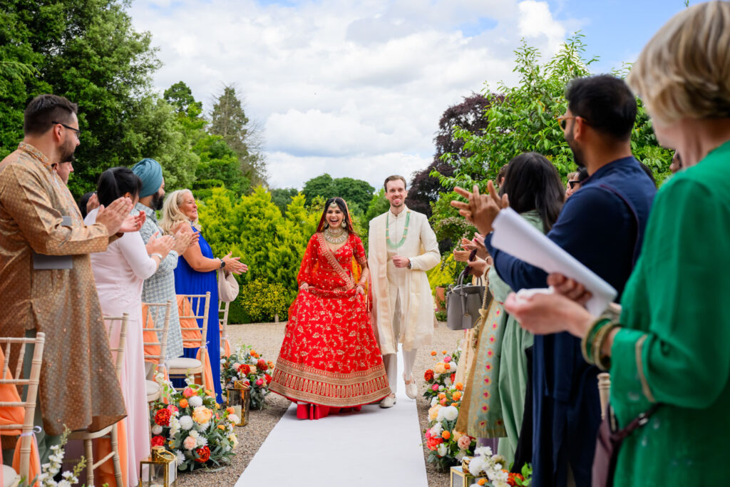 Bride and groom making their entrance to the outdoor ceremony at Manor by the Lake.