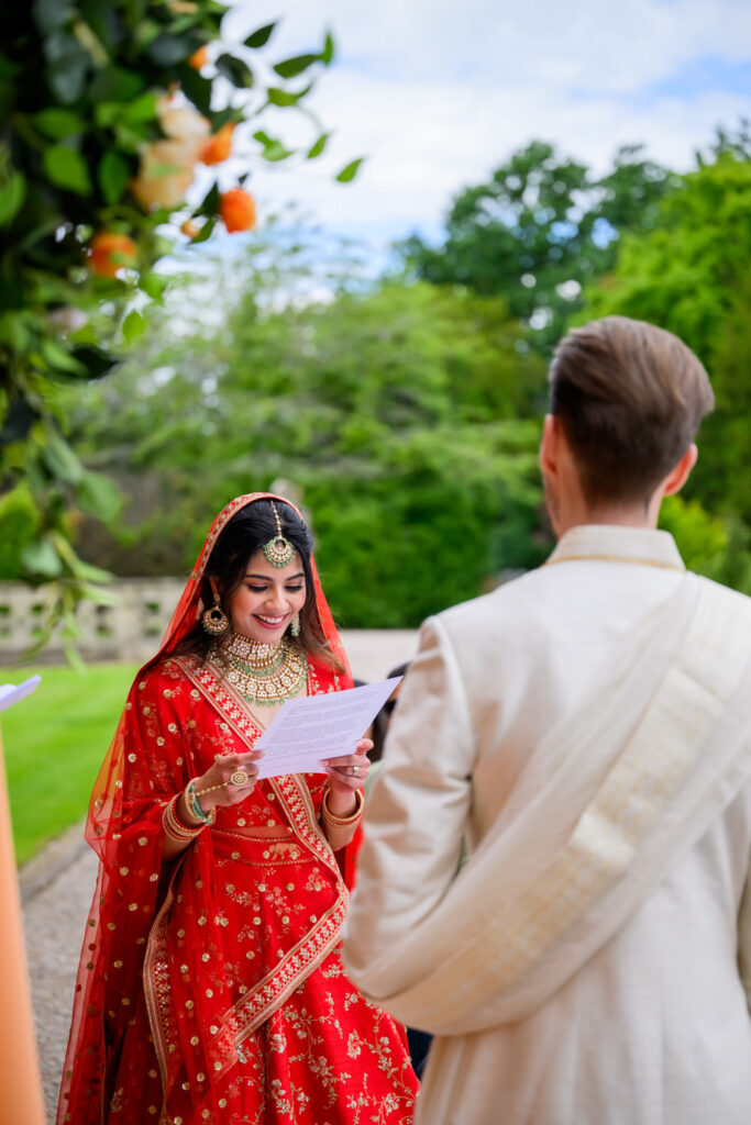 Bride reading her vows during an outdoor wedding ceremony at Manor by the Lake.
